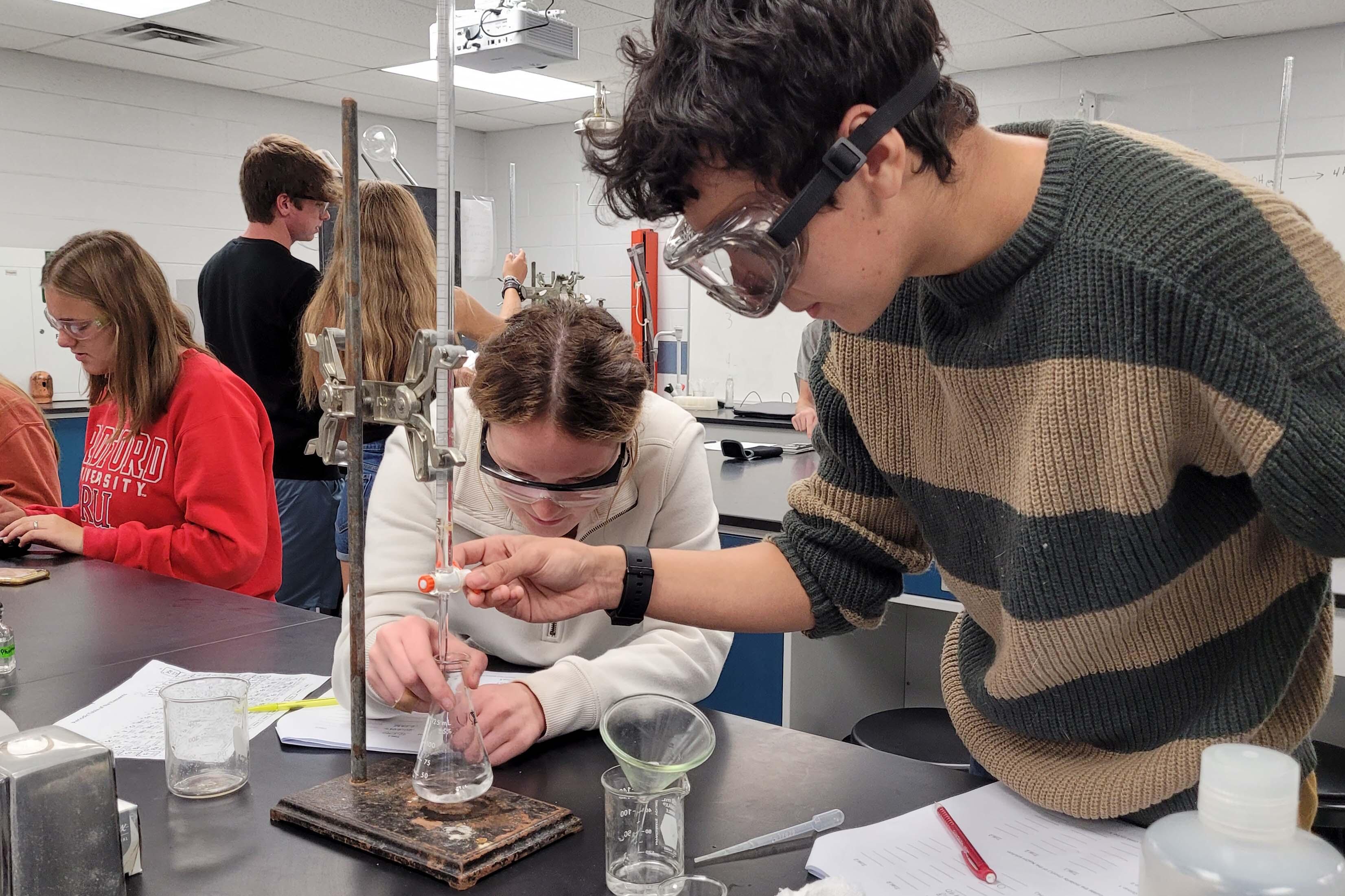 Students in College Chemistry complete a titration experiment.